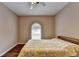 Bedroom featuring a ceiling fan, wood floors, and arched window at 2694 Sterling Dr, Lawrenceville, GA 30043