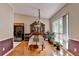 Traditional dining room with an antique hutch, chandelier, plants, and natural light from the large window at 2694 Sterling Dr, Lawrenceville, GA 30043