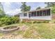 Backyard with a stone firepit, brick base, screened porch and lush greenery at 2118 Allaire Ne Ln, Atlanta, GA 30345