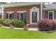 Close-up of brick front featuring flower beds and front door with decorative trim at 2118 Allaire Ne Ln, Atlanta, GA 30345