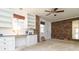 Office area featuring white cabinets, a brick wall, and neutral carpet at 2118 Allaire Ne Ln, Atlanta, GA 30345