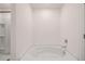 Bright bathroom features a soaking tub with a white surround and a door leading to a closet at 215 Amberjack Trail, Covington, GA 30016