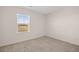 Well-lit bedroom with neutral colored carpet and a window providing exterior views at 215 Amberjack Trail, Covington, GA 30016
