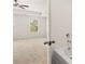 Bright bedroom with a ceiling fan, carpet floors, and a bathroom that features a soaking tub at 215 Amberjack Trail, Covington, GA 30016