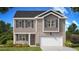 Two story home featuring a gray brick, two car garage, with lush landscaping at 215 Amberjack Trail, Covington, GA 30016