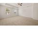 Spacious main bedroom featuring tray ceiling, ceiling fan, neutral carpeting, and large windows at 215 Amberjack Trail, Covington, GA 30016