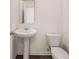 Close-up of the powder room with a white pedestal sink and toilet at 215 Amberjack Trail, Covington, GA 30016