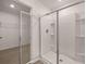 Modern bathroom with a glass-enclosed shower with built-in shelving and a view into the walk-in closet at 215 Amberjack Trail, Covington, GA 30016