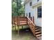 Wood deck with stairs leading down to the yard with railings and wooden supports at 5142 Fawn Sw Ln, Conyers, GA 30094