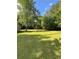 Expansive and lush backyard with mature trees and well-maintained lawn, perfect for outdoor activities and relaxation at 5142 Fawn Sw Ln, Conyers, GA 30094