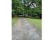 Long, paved driveway leading to a home with a lush green lawn on both sides, bordered by mature trees at 5142 Fawn Sw Ln, Conyers, GA 30094