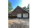 Two-car garage in a brick home with a paved driveway and side yard at 5142 Fawn Sw Ln, Conyers, GA 30094