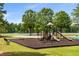 Community playground near the lake with mature shade trees at 7994 Larksview Dr, Fairburn, GA 30213