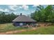 Rear exterior showcasing a patio, screened in area, and expansive yard, perfect for outdoor living at 1056 Riverstone Dr, Social Circle, GA 30025