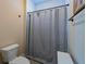 Bathroom features a shower with decorative curtain, toilet, and storage cabinet at 1056 Riverstone Dr, Social Circle, GA 30025