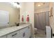 Bathroom features granite countertop, white vanity, large mirror, and shower with decorative curtain at 1056 Riverstone Dr, Social Circle, GA 30025
