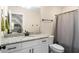 Bathroom features granite countertop, white vanity, and shower with decorative curtain at 1056 Riverstone Dr, Social Circle, GA 30025