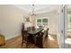 Dining room with hardwood floors, elegant chandelier, and natural light from large windows at 1056 Riverstone Dr, Social Circle, GA 30025
