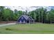 Charming blue two-story home with a landscaped yard and long driveway in a wooded location at 1056 Riverstone Dr, Social Circle, GA 30025