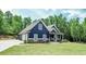 Charming blue two-story home with a landscaped yard, and an attached two-car garage at 1056 Riverstone Dr, Social Circle, GA 30025
