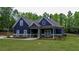 Charming blue two-story home with a landscaped yard and inviting front porch at 1056 Riverstone Dr, Social Circle, GA 30025