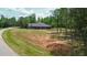 Exterior elevation on a large lot; house with a dark roof and a big yard at 1056 Riverstone Dr, Social Circle, GA 30025