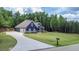 Charming blue two-story home with a landscaped yard, long driveway, and attached two-car garage at 1056 Riverstone Dr, Social Circle, GA 30025