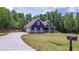 Charming blue two-story home with a landscaped yard and long driveway in a wooded location at 1056 Riverstone Dr, Social Circle, GA 30025