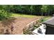 Landscaped patio area with planter boxes, fencing, and view of wooded backyard at 1056 Riverstone Dr, Social Circle, GA 30025