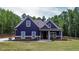 Charming blue house with a well-manicured lawn and inviting front porch surrounded by lush, mature trees at 1056 Riverstone Dr, Social Circle, GA 30025
