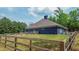 A fenced in backyard of a modern home with a well-maintained lawn and mature trees at 1056 Riverstone Dr, Social Circle, GA 30025