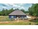 Exterior rear view of a home with a screened in porch and a lovely outdoor seating area at 1056 Riverstone Dr, Social Circle, GA 30025