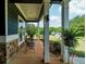 Spacious front porch with seating, stone pillars, and a view of the manicured front yard and surrounding landscape at 1056 Riverstone Dr, Social Circle, GA 30025