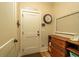 Hallway with wooden dresser, picture frames, and door to a closet or storage room at 1056 Riverstone Dr, Social Circle, GA 30025