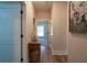 Hallway with wood floors and trim features an antique table and whimsical pig portrait at 1056 Riverstone Dr, Social Circle, GA 30025