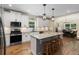 Bright kitchen with white cabinets, granite countertops, stainless appliances, and breakfast bar island seating at 1056 Riverstone Dr, Social Circle, GA 30025
