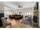 Spacious living room with hardwood floors, a stone fireplace, and plenty of natural light from large windows at 1056 Riverstone Dr, Social Circle, GA 30025