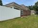 Brick home's backyard featuring a white fence and well-maintained lawn at 1266 Laurelwood Ct, Lawrenceville, GA 30045