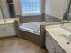 Bathroom features a soaking tub, tile surround, and dual vanity at 1266 Laurelwood Ct, Lawrenceville, GA 30045