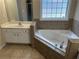 Bathroom features a soaking tub, tile surround, and single vanity at 1266 Laurelwood Ct, Lawrenceville, GA 30045