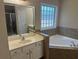 Well lit primary bathroom features a soaking tub, glass block window, and double sink vanity at 1266 Laurelwood Ct, Lawrenceville, GA 30045