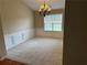 Formal dining area features a chandelier, large window, chair rail, and neutral carpet at 1266 Laurelwood Ct, Lawrenceville, GA 30045