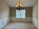 A dining room with decorative trim, plush carpeting, and a classic chandelier at 1266 Laurelwood Ct, Lawrenceville, GA 30045