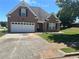 Brick home with attached garage on a sunny day at 1266 Laurelwood Ct, Lawrenceville, GA 30045