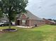 A charming red brick home with lush green grass and a mature tree in the front yard at 1266 Laurelwood Ct, Lawrenceville, GA 30045