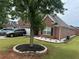 Red brick home with manicured landscaping, showcasing the front yard and two-car garage at 1266 Laurelwood Ct, Lawrenceville, GA 30045