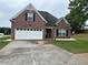 Charming brick front home with a two-car garage, well-maintained lawn, and black shutters at 1266 Laurelwood Ct, Lawrenceville, GA 30045