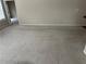 Spacious living area featuring neutral carpet leading to a doorway and hardwood flooring in the background at 1266 Laurelwood Ct, Lawrenceville, GA 30045