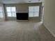 Comfortable living room featuring a fireplace, large windows, and neutral carpeting, perfect for relaxation at 1266 Laurelwood Ct, Lawrenceville, GA 30045