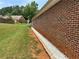 Exterior view of brick home featuring a manicured lawn and effective drainage system at 1266 Laurelwood Ct, Lawrenceville, GA 30045